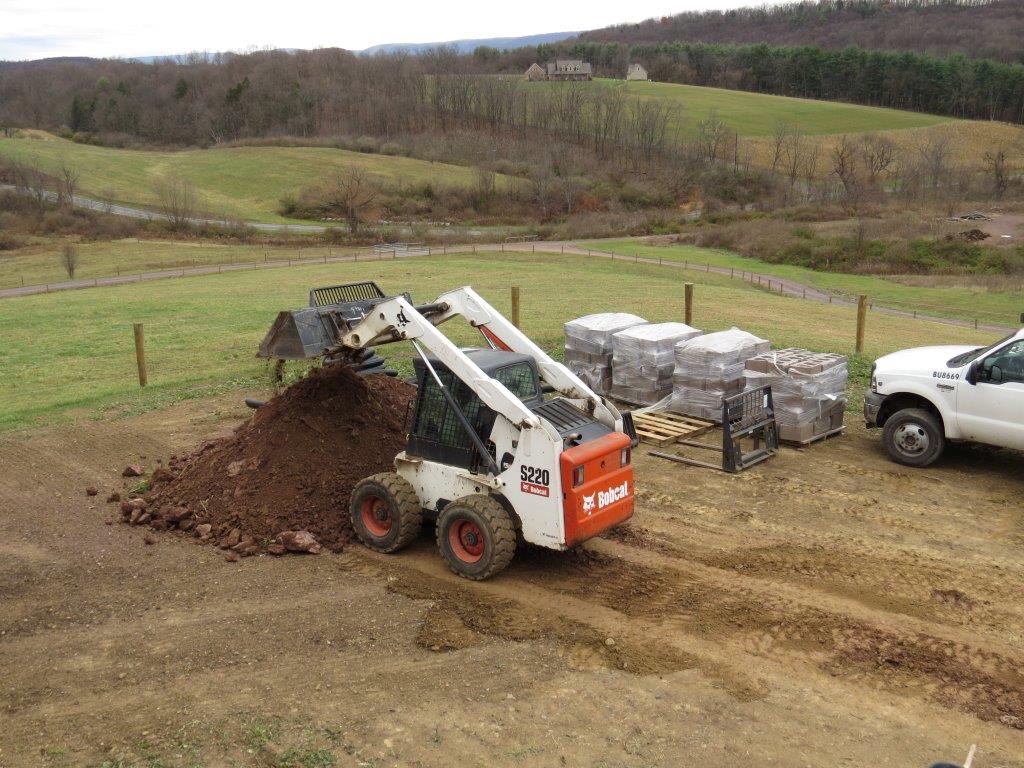 Skid-steer loader moving dirt on construction site